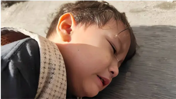 Yanaklarından gözyaşları süzülen, üzüntüsünü ve duygusal sıkıntısını ifade eden genç bir çocuk.