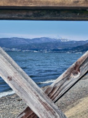 Arka planda dağlar olan mavi gölün güzel manzarası, güneşli kış günü. 