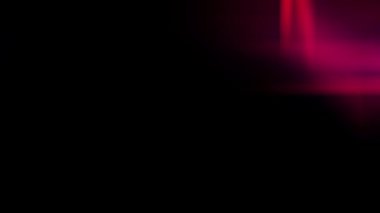 Bu video, koyu siyah bir arkaplan karşısında parlak kırmızı ve pembe ışık çizgileri ya da mercek parlamalarını içerir.