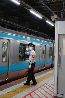 Tren geldiğinde, Japon İstasyonu 'ndaki tren subayı işini yapıyordu.