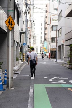 Sokakta yürüyen Japon çocuk.