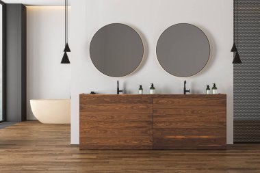 Parke zeminli parlak banyo, çift bej lavabo, ahşap kibir, bej küvet, tuvalet ve oval aynalar, büyük pencere. Modern mobilyaları olan minimalist, rahat bir banyo. 3d oluşturma