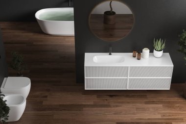 Gri duvarları, parke zemini, siyah musluğu, çekmecesi, duvarında oval aynası, bitkileri, küveti, tuvaleti, taharet musluğu olan modern koyu renk bir banyo. 3d oluşturma