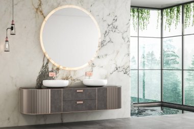 Çift lavabo kibri, mermer duvarlar, beton döşeme, küçük bir havuz ve pencere manzaralı bir orman manzarası olan lüks bir banyo.