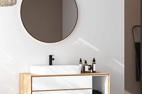 Close up of sink with oval mirror standing in on white wall , white cabinet with black faucet in minimalist bathroom. Side view. 3d rendering