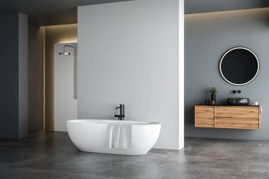 Modern banyo içi mavi ve beyaz tonlu duvar, beton zemin, siyah lavabo ve oval aynalı ahşap kibir, beyaz küvet, panoramik pencereler.