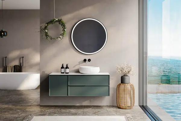modern banyo bej ve toprak renkli duvarlar, beyaz küvet, yeşil kibir, siyah ayna, lavabo, terrazzo zemin ve pencereden deniz manzarası.