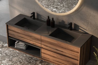 Koyu gri duvarda asılı oval aynalı çift leğen, minimalist banyoda siyah muslukları olan modern dolap..