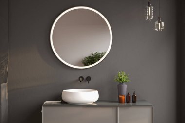 Sabun, havlu, bitki ve siyah çerçeveli ayna ile şık bir banyo düzeneği.