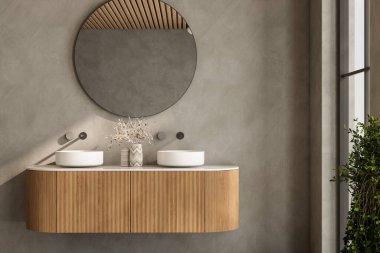 Büyük aynalı ve lavabolu bir banyo. Ayna yuvarlak ve lavabo beyaz.