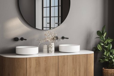 Çift lavabo ve banyodaki bitkiyi kapatın. Banyo modern ve temiz görünüyor.