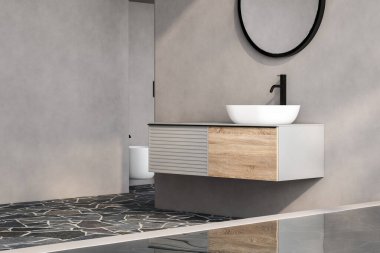 Şık gri banyo döşemesi, tuvalet, büyük küvet ve oval aynalı beyaz lavabo ve ahşap kibir..