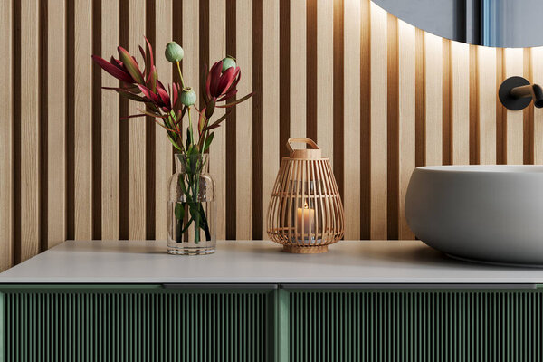 Крупный план современной ванной комнаты тщеславие со стеклянной вазой, содержащей цветы, деревянный фонарь свечи, и керамический умывальник против деревянной реечной стены. 3D рендеринг