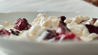 Kızarmış kırmızı biber kızartması ve yoğurt sunumu. Tabakta beyaz yoğurt ve kızarmış kırmızı capia biberi resmi. 