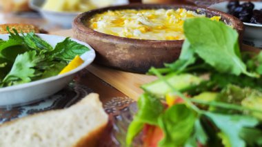 Açık arazide, çardakta kahvaltı. Harika bir kil tabakta peynirli omlet. yeşil diyet salatası