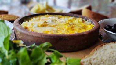 Açık arazide, çardakta kahvaltı. Harika bir kil tabakta peynirli omlet. yeşil diyet salatası