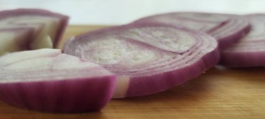 Mor soğan halkalar halinde doğranmış. Tahtada güzel bir sunum fotoğrafı.