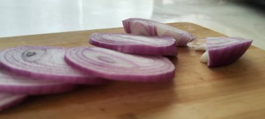 Mor soğan halkalar halinde doğranmış. Tahtada güzel bir sunum fotoğrafı.