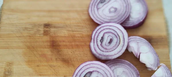 Purple onion chopped into rings. Beautiful presentation photo on blackboard.