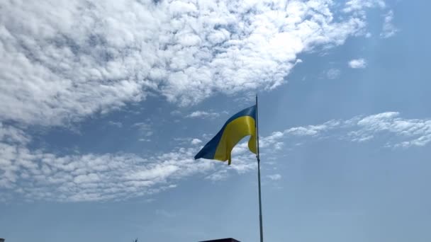 乌克兰国旗在蓝天的背景下缓慢地飘扬 乌克兰的国旗是黄蓝色的 乌克兰的国旗在风中飘扬 风是国家的象征 乌克兰的国旗飘扬着 — 图库视频影像