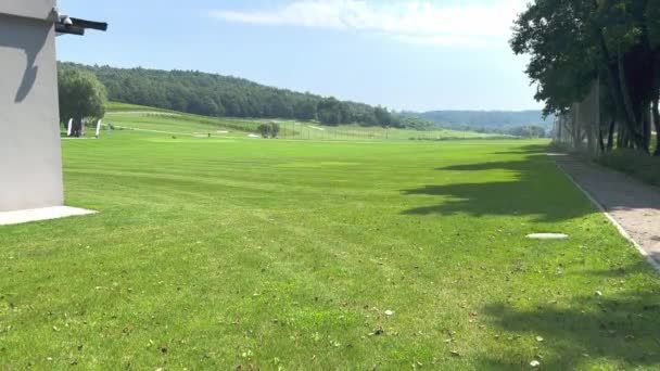 一个阳光灿烂的夏天 在一个高尔夫俱乐部附近 有一个巨大的绿色草坪 草坪上有修剪过的高尔夫球草 一个绿色修剪过的大草坪 — 图库视频影像