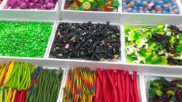 糖果店里各种色彩艳丽的果冻糖果 在商店柜台上的各式各样的多色果冻糖果 各种形状和颜色的果冻糖果 — 图库视频影像