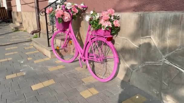 Różowy Rower Kwiatami Koszu Zaparkowany Jest Pobliżu Budynku Przy Ulicy — Wideo stockowe