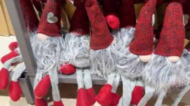 Kırmızı koni şapkalı ve gri sakallı birçok elf bir rafta yan yana otururlar. Kırmızı bir Noel elfi yeni yıl arifesinde evleri süslüyor. Mağazada yeni yıl oyuncakları satılıyor..