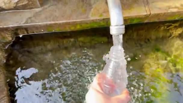 用从泉水中流出的新鲜的 干净的饮用水填满一小瓶 水龙头一种金属水龙头 春天的水从它的手中注入瓶子来自自然水源的饮用水 — 图库视频影像