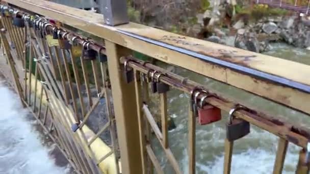 Ερωτικά Λουκέτα Μια Πεζογέφυρα Απέναντι Από Ποτάμι Πολλές Κλειδαριές Είναι — Αρχείο Βίντεο