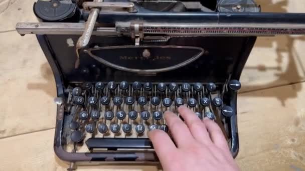 一个人的手按住了站在木制桌子上的一台老式机械式打字机上的键 用黑色的旧打字机打字 — 图库视频影像