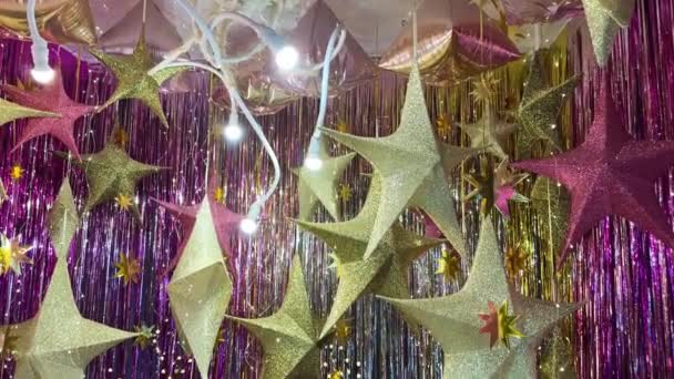 インテリアの明るいお祝いの装飾 黄金の星 ガーランド ギフトボックスとクリスマスと新年の背景 星と星の背景にカラフルなギフトボックス — ストック動画