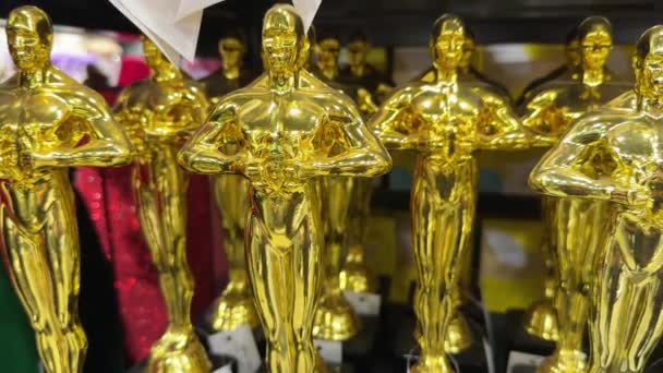 多くの金色のオスカー像が棚に飾られています ギフトショップのゴールドアワードまたはトロフィー 競争に勝つための賞 そして成功の概念 — ストック動画