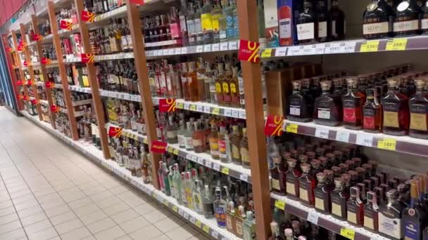 超市里有各种含酒精饮料的货架和打折标志 这家商店酒类部的许多酒瓶 — 图库视频影像