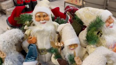 Mağazada Noel Baba 'nın yumuşak oyuncakları. Fuarda beyaz sakallı ve beyaz şapkalı birçok farklı Noel Baba kışlık kalın kıyafetler giyiyor. Noel Baba Noel 'in sembolüdür..