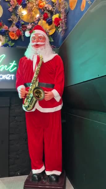 Bild Jultomten Som Håller Saxofon Står Framför Ingången Till Nöjesplats — Stockvideo