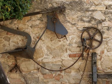 Paslı demir aletler ve duvardaki metal zincir.