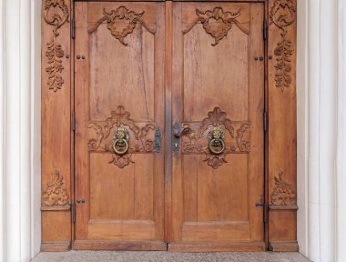 Karmaşık oymalar ve Pirinç Aslan Memeleri ile Süslemeli Ahşap Çift Kapı