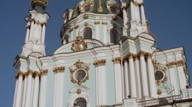 Podil bölgesindeki eski ortodoks kilisesinin panoramik videosu. Altın kubbeler gün batımında parlıyor, St. Andrew Kilisesi, Kyiv, Ukrayna
