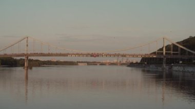 Dnipro Nehri 'ne bakan yaya köprüsünün genel planı. Gün batımı. Yaz. Ukrayna. Kyiv.