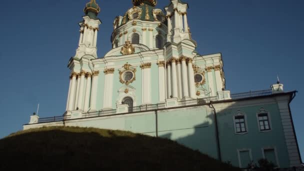 ポディル地区の古い正統派教会を見る 金色のドームは日没 セントアンドリュー教会 キエフ ウクライナで光ります — ストック動画