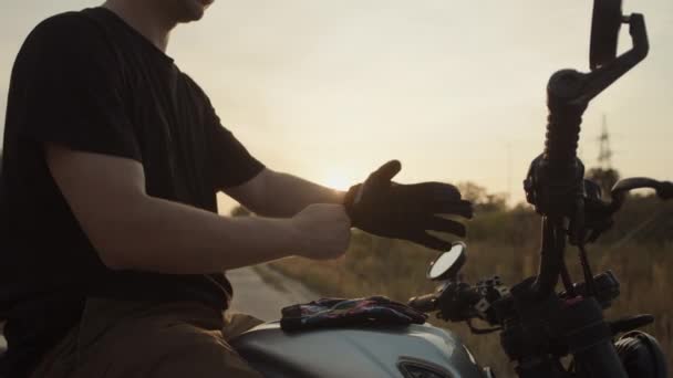Motorkář Při Západu Slunce Nasadí Rukavice — Stock video