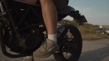 Şık motosikletli yetenekli motosikletçi gazları ve sürmeye başla. 