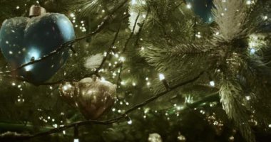 Çelenkle süslenmiş bir Noel ağacının yeşil dallarına yakın dur..