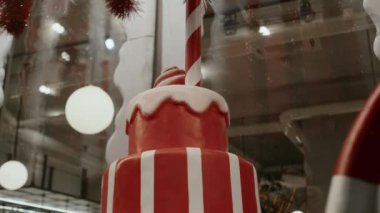 Atmosferik kafe yakınlarında büyük, kırmızı, şenlikli bir yeni yıl pastası süslemesi.