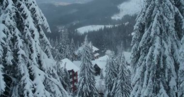 Karla kaplı sık ormanlı dağların güzel kış manzarası. Köy yokuş aşağı.