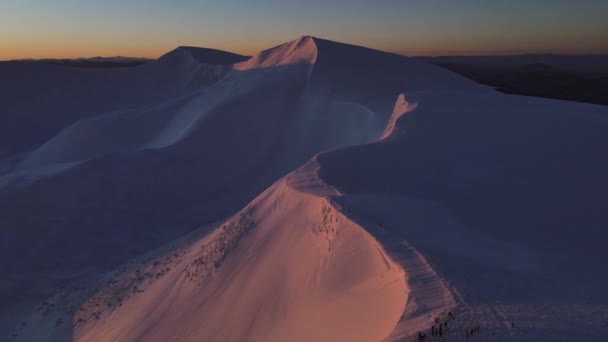 太陽は山で昇り始め 雪の多い冬の山々にピンクの光で触れ始める — ストック動画