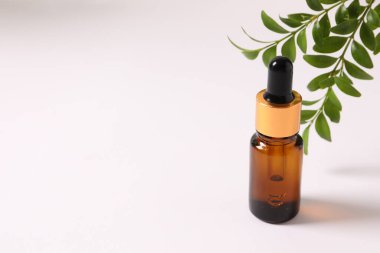 bottle of pipette with serum and essential oil on light background