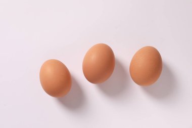 Beyaz kağıtta farklı boyutlarda yumurtalar.