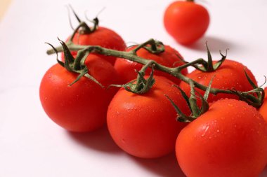 Kırmızı kiraz domatesleri, beyaz arka planda taze organik kiraz domatesleri, yakın plan -.